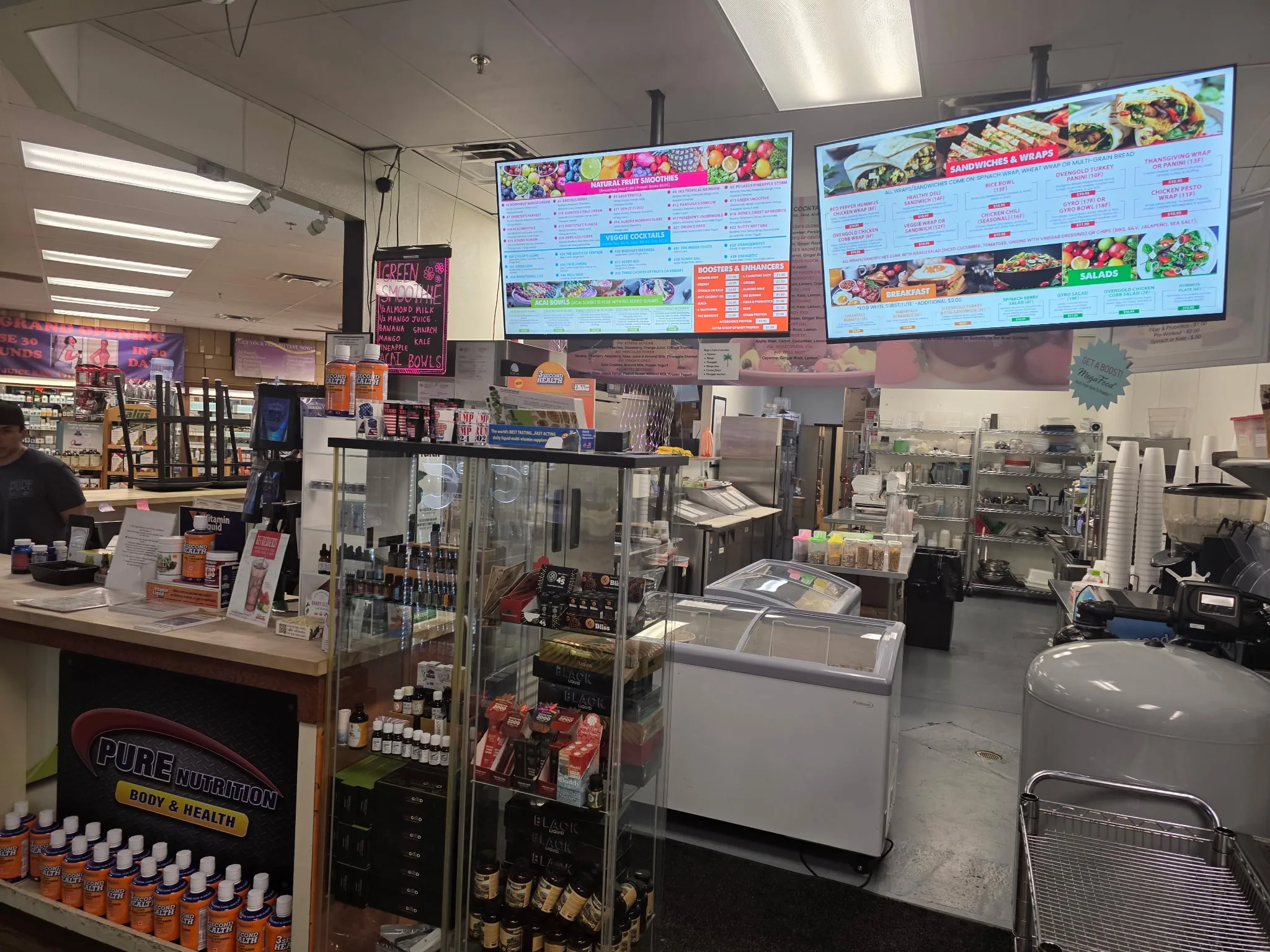 Interior of Pure Nutrition vitamin and supplements store with menu boards and counter.
